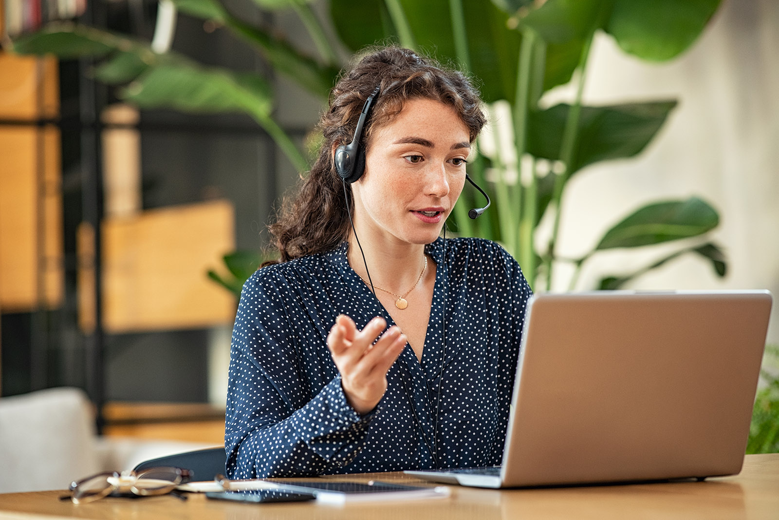 woman with headphones talking on laptop