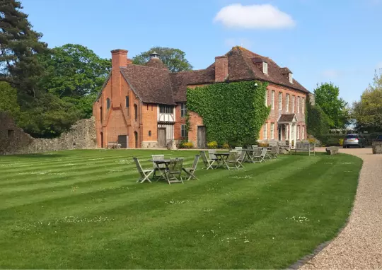 big house on the grounds with lawn tables and chairs - family open day